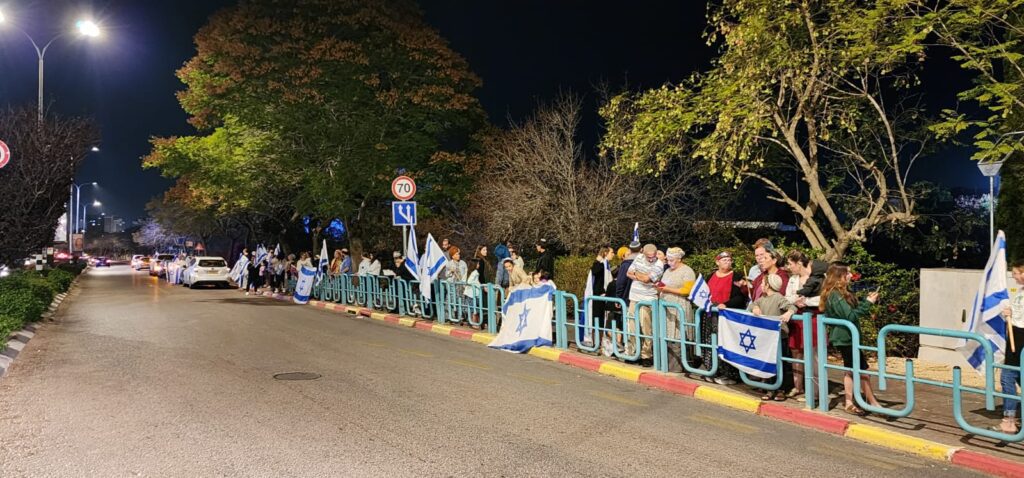 מסע הלוויה במעלות: אנשים עומדים עם דגלים