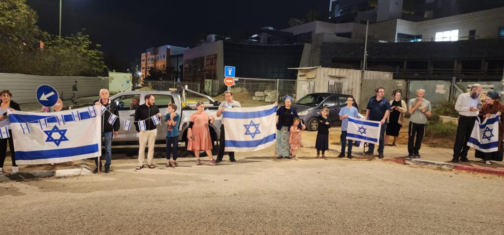 מסע הלוויה במעלות: אנשים עומדים עם דגלים