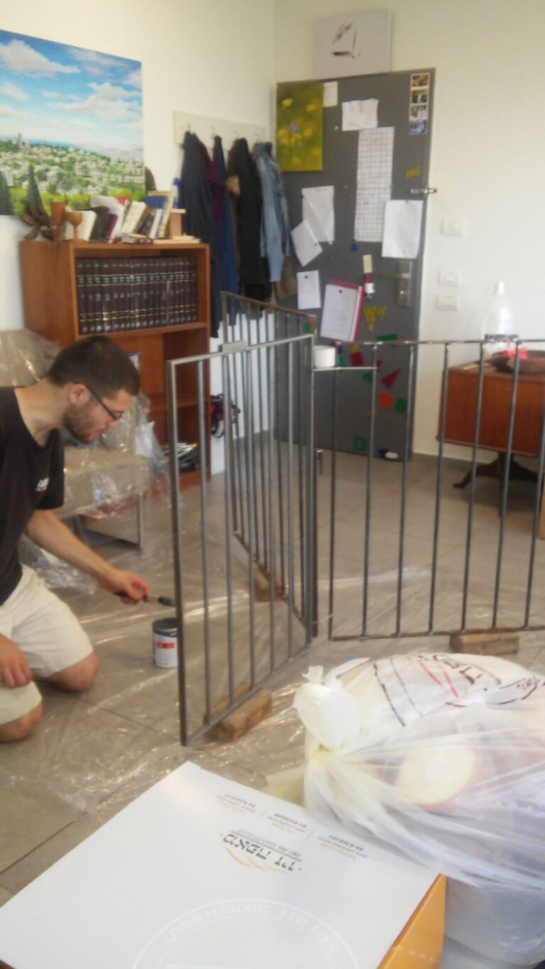 עובד על הסורגים על רצפה מכוסה ניילון