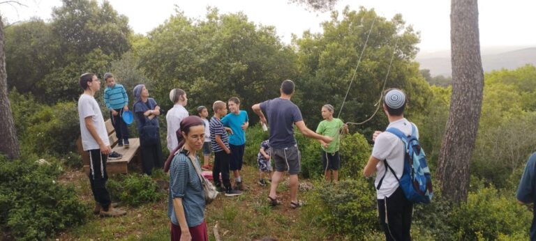 המשפחה מתאספת סביב הנדנדה בחורשה